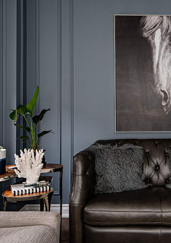 detail corner of room featuring a leather couch and horse painting